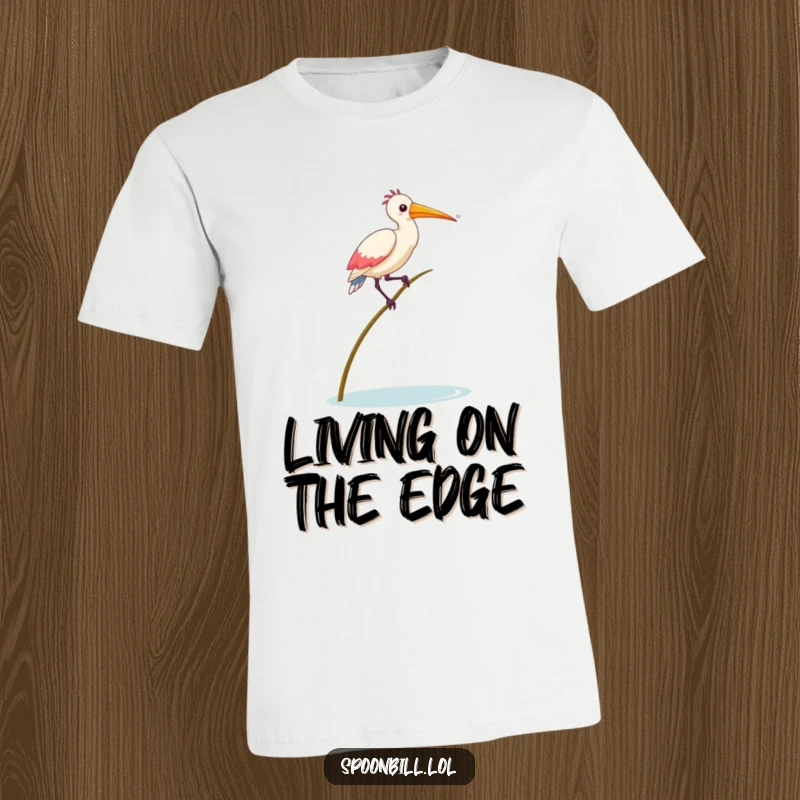 Funny Balancing Spoonbill Bird T-Shirt depicting a spoonbill bird struggling comically to balance on a thin reed, showcasing playful instability.