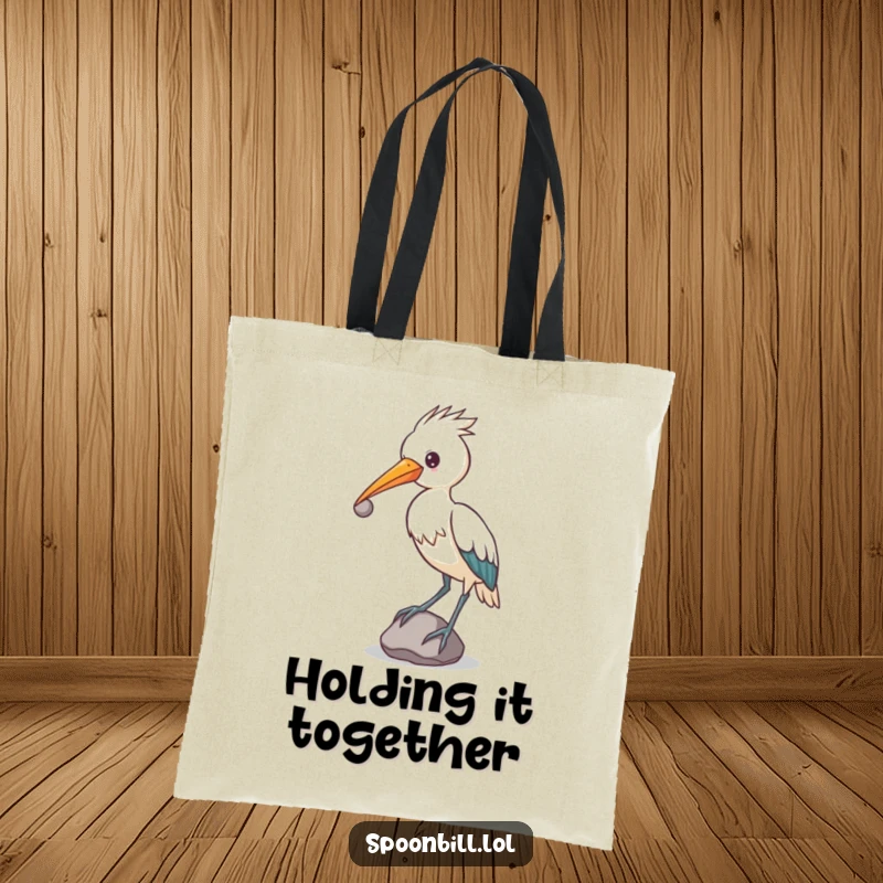 Funny determined spoonbill bird balancing a small, round stone on its beak, unique tote bag.